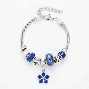 Detail of silver snake chain bracelet with blue enamel flower charms and crystal beads