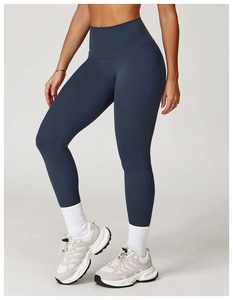 Detail der dunkelblauen Yoga-Leggings mit hohem Bund, weißen Socken und Sportschuhen