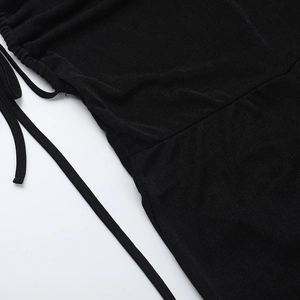 Close-up of black knitted fabric detailing with ruched design and drawstring ties