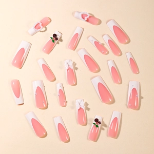 Detail of French press-on nails with 3D cherry, bow, and pearl heart decorations