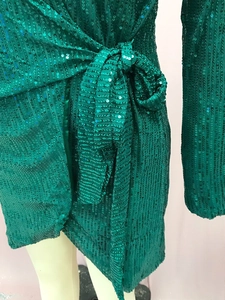 Dettaglio della vita di un abito verde di paillettes con cintura da annodare avvolgente