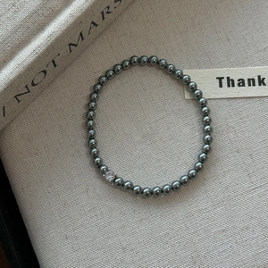 Bracelet élégant en perles gris foncé métallisées avec un zircon blanc étincelant