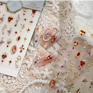 Macro view of Baroque nail stickers with gold angels and red heart designs