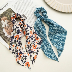 Elastici per capelli a fiori con nastri lunghi in beige e blu scuro su sfondo bianco