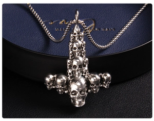 Detailed macro view of silver punk skull cross pendant and stainless steel box chain