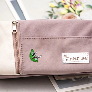 Épinglette en émail cosse de pois verte avec couteau sur une trousse en toile beige