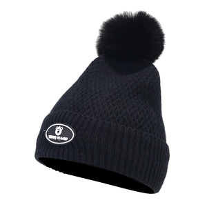 Close-up of black winter knit hat with large pom-pom and teddy bear brand logo patch