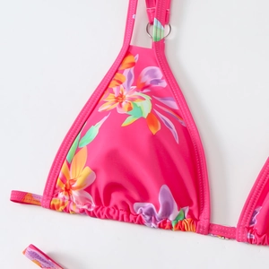 Detail of floral bikini top with silver metal rings and vibrant tropical pattern