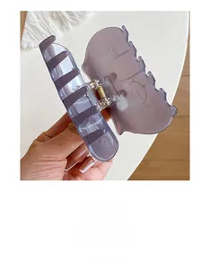 Detail of purple translucent claw clip with minimalist cartoon cat illustration