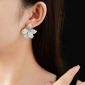 Detailaufnahme der Zirkonia-Blumenohrringe mit glitzernden Steinen am Model