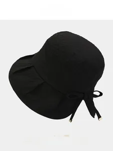 Detail of woven fabric texture and bow with metal trim on a foldable sun bucket hat