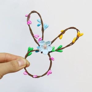 Detail of a handmade woven bunny ear napkin ring with colorful floral accents