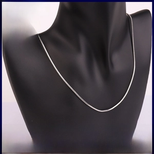 Close-up of polished stainless steel snake chain necklace with dense metallic link texture