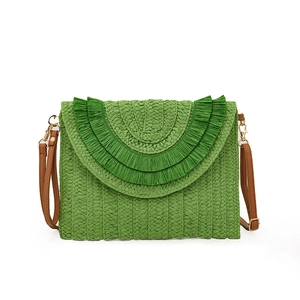 Detail of green raffia woven clutch showing fringe texture and brown leather strap