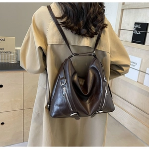 Detail of soft dark brown leather backpack with silver zippers and large capacity