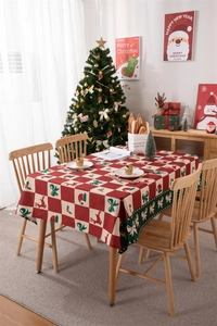 Close-up of festive Christmas tablecloth with reindeer and plaid patterns on a dining table