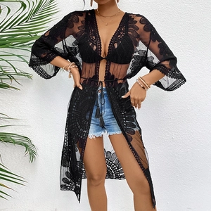 Detail of black lace crochet kimono cardigan with tassel ties and embroidery texture