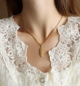 Close-up of a 18K gold plated oval pendant necklace with a vintage religious relief