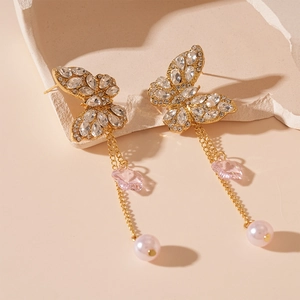 Macro view of crystal flower with rhinestone butterfly and elegant pearl tassel earring