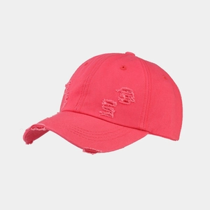 Detailed view of distressed washed cotton baseball cap with vintage frayed edges and holes