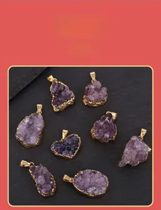 Detailed macro view of raw purple amethyst pendants with gold plated irregular edges