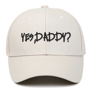 Close-up of Yes Daddy black embroidery on a beige cotton baseball cap with fine stitching