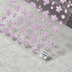 Detail view of 3D embossed pink cherry blossom nail stickers on a stone surface