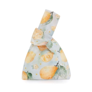 Detail of soft velvet knot wrist bag with watercolor lemon print and leaf pattern