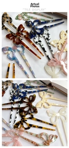 Close-up of butterfly-shaped acetate hairpins with diverse tortoiseshell and marble patterns