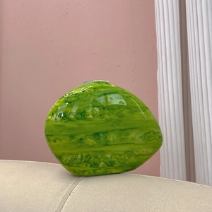Detailed view of green marble-pattern oval bag with a high-gloss finish and unique shape