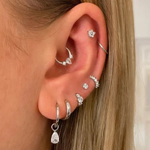 Close-up of S925 sterling silver heart and star earrings with cubic zirconia on model ear
