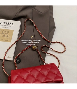 Detail of red quilted leather bag with gold chain strap and adjustable ball slider buckle