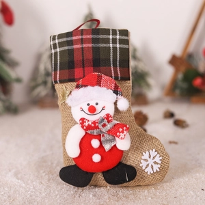 Detail of burlap Christmas stocking featuring a 3D snowman with red checkered hat and stars