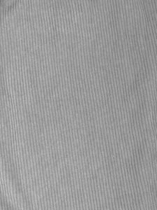 Macro detail of light grey corduroy fabric texture showing vertical ribbed patterns