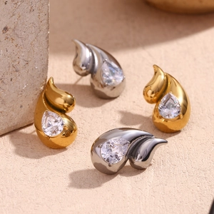 Macro view of teardrop zircon earrings in gold and silver finish with mother of pearl detail