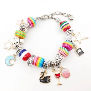 Detailed macro view of colorful resin barrel beads and charms on a metal chain bracelet