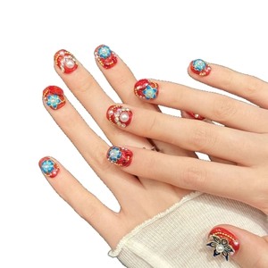 Ongles à presser rouges avec relief floral bleu 3D et accents de perles