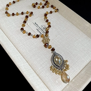 Macro shot of vintage beaded necklace with amber crystal pendant in decorative box