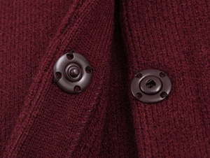 Vue macro détaillée de la texture tricotée bordeaux avec des boutons-pression en métal