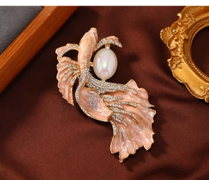 Detail of pink enamel goldfish brooch with sparkling crystals and a faux pearl accent
