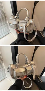 Detailed view of silver metallic cylindrical saddle bag with dual front pockets and buckles
