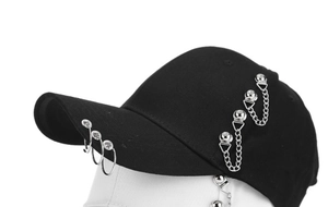 Detail of black baseball cap with silver metal rings and hanging chain accessories