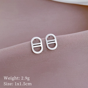 Close-up of silver oval cutout titanium earrings with detailed size and weight specs