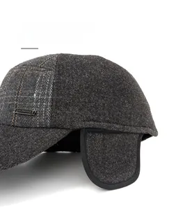 Détail des protège-oreilles rembourrés et de la texture laine sur la casquette d'hiver