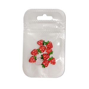 Translucent strawberry fruit resin nail art charms in packaging for DIY manicures