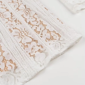 Close-up of elegant white floral lace fabric with intricate mesh patterns and elastic texture