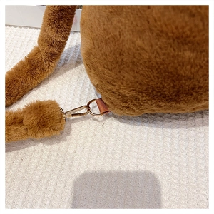 Detailed close-up of the metal buckle and brown strap on a plush Capybara backpack
