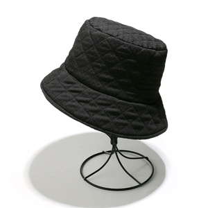 Detail of black quilted bucket hat with classic rhombus pattern and padded texture