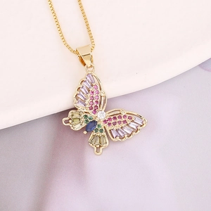 Close-up of golden butterfly necklace with colorful zircon gemstones on soft fabric