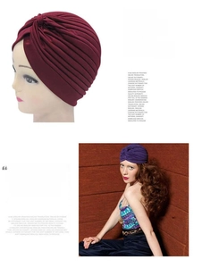 Detail of pleated knit turbans in burgundy and purple for winter warmth and comfort